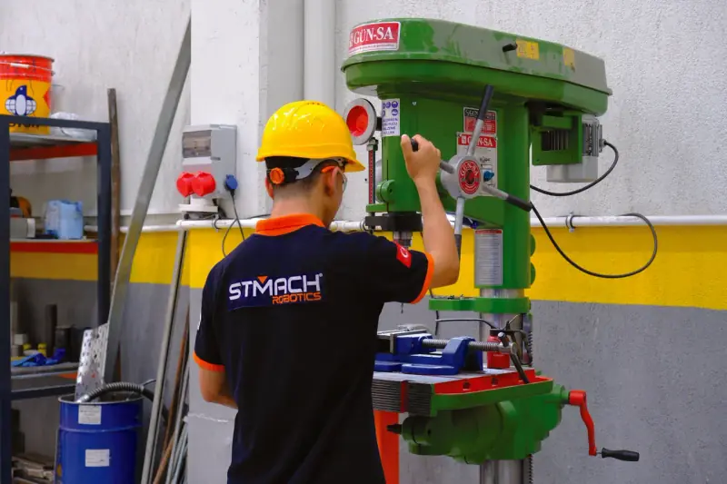 STMACH Robotics atölyesinde sütunlu matkapta parça işleyen teknisyen